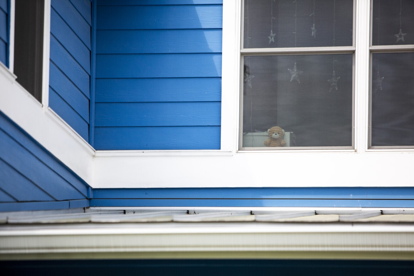 A small, striped bear peeks through a second-story window in Rosedale.